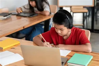 Anak belajar sambil mendengarkan musik menggunakan headphone untuk meningkatkan konsentrasi.